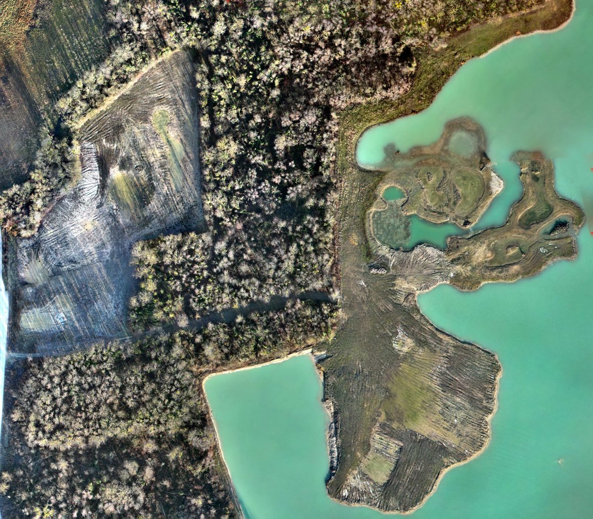 Gravière en cours de réaménagement vue par drone : îlots, hauts-fonds et berges en terrassement au bord du plan d'eau