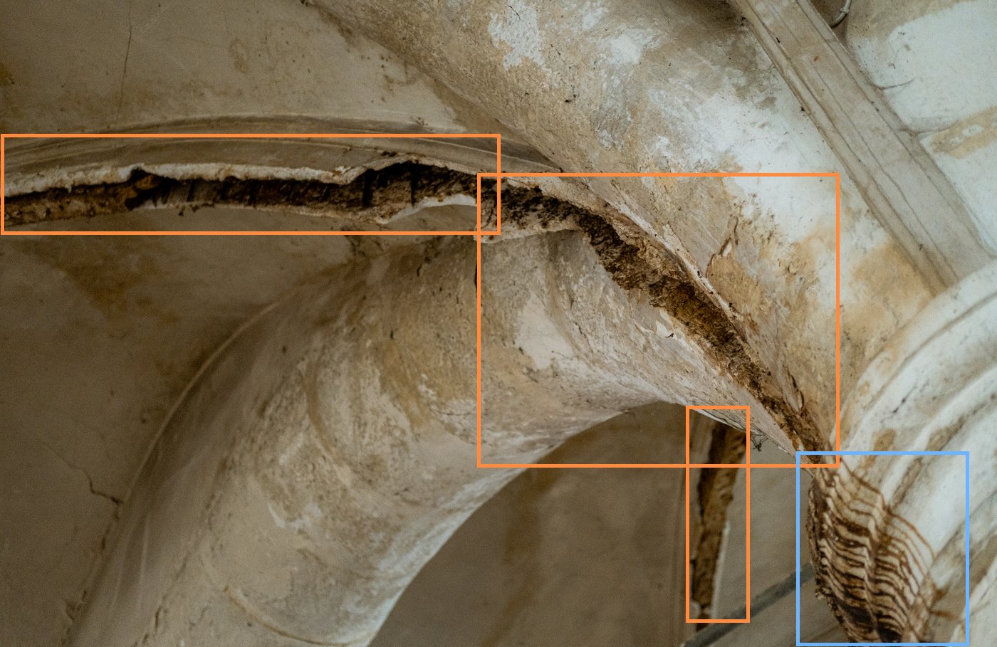 Open joints along a vault arch, fallen material and run-off marks on a capital